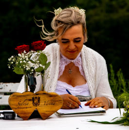 Zeigt Verena Bedlan am Steinerhof sitzend am tisch bei der Unterschrift während der Standesamtlichen Trauung